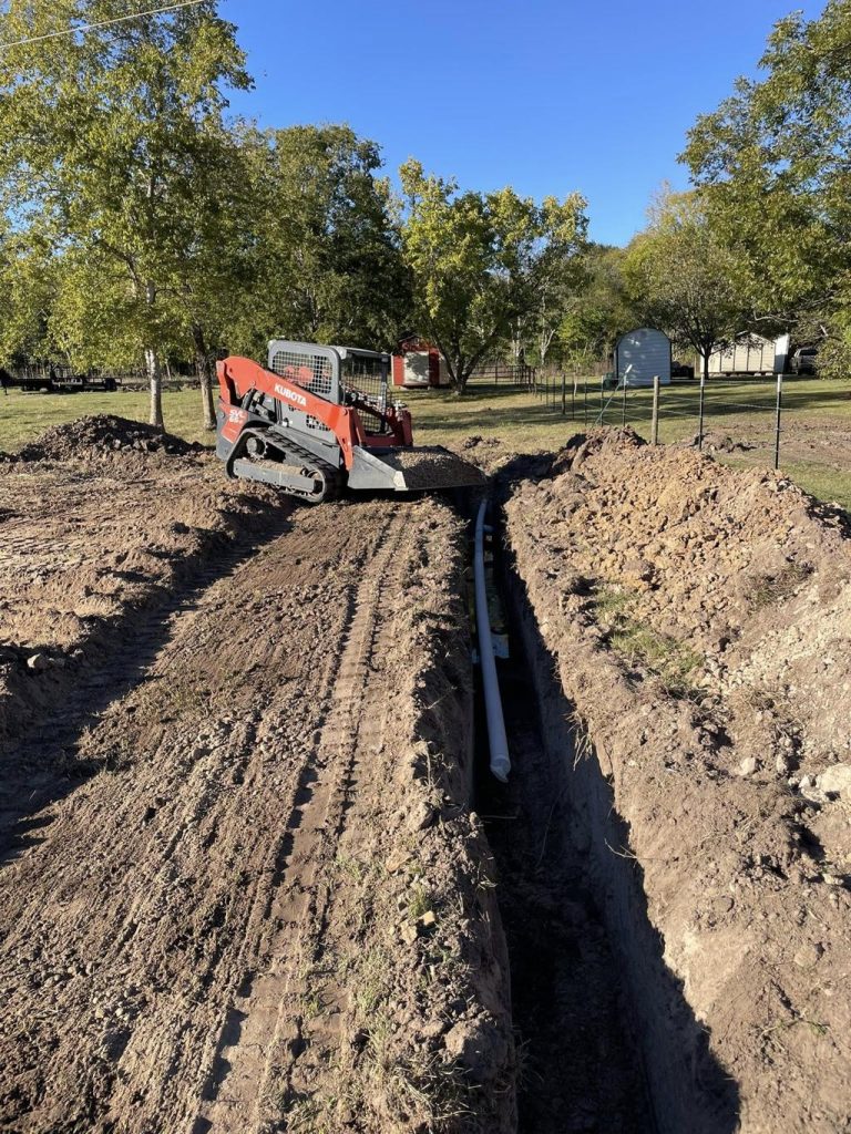 Trencher cutting through hard dry Texas clay soil in Abilene
