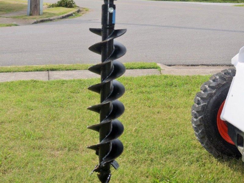 Deck footing drilling with skid steer auger in Abilene TX